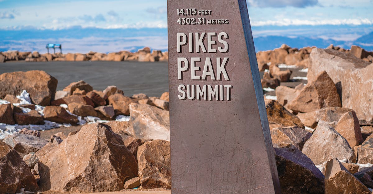 Scenic view of the Pikes Peak Summit sign surrounded by rocky terrain in Colorado.
