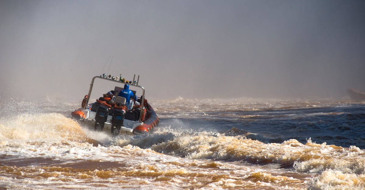 A motorboat speeds through turbulent river rapids, creating splashing waves.