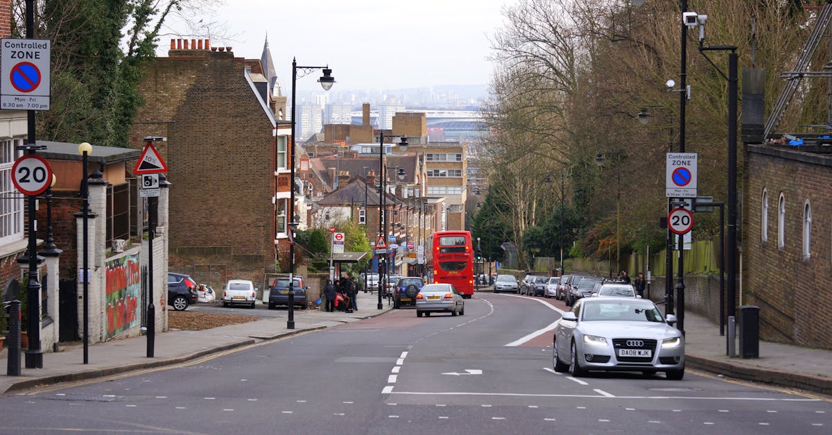 City street scene featuring a red double-decker bus, cars, and buildings, capturing urban life.