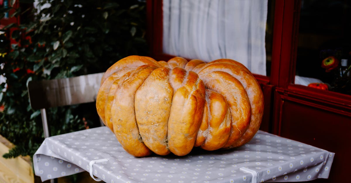 A large pumpkin sits on a decorative table outdoors, perfect for autumn themes.