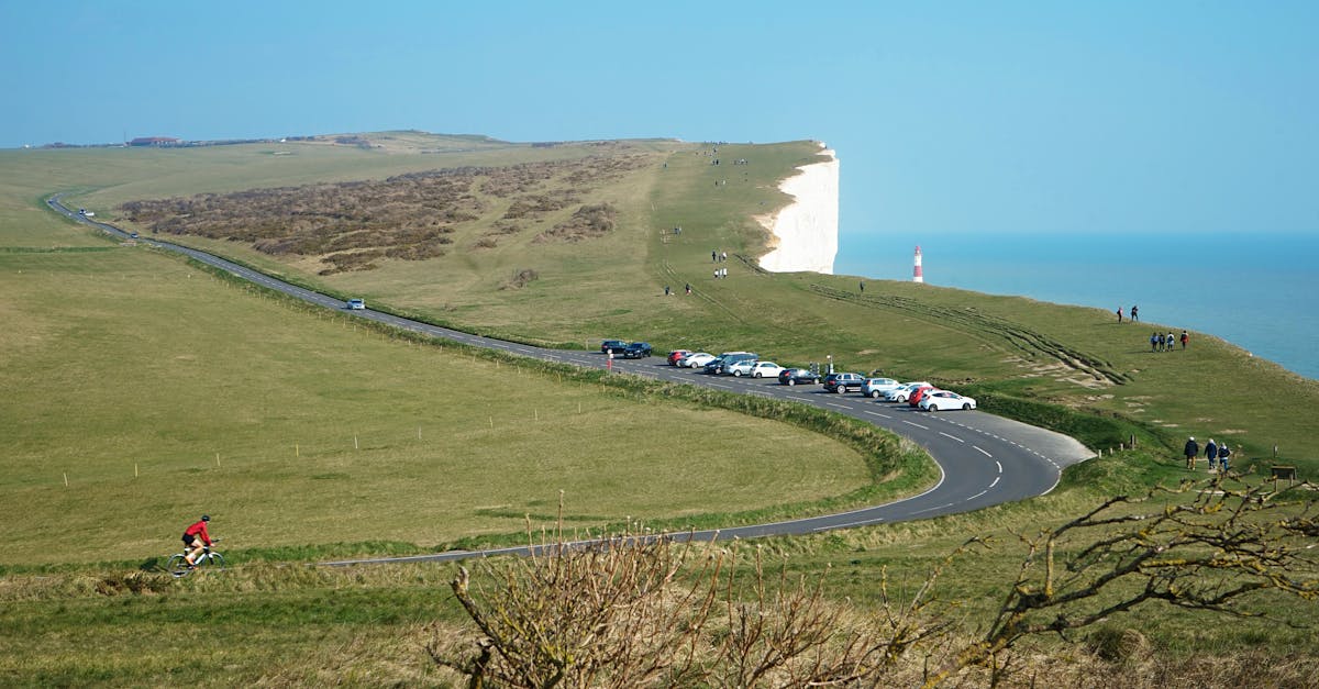 Breathtaking view of Eastbourne cliffs with cyclist and coastal road, ideal for travel enthusiasts.
