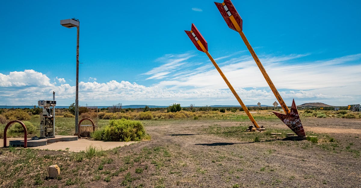 Two iconic giant arrows in the desert near Flagstaff, Arizona under a clear blue sky.