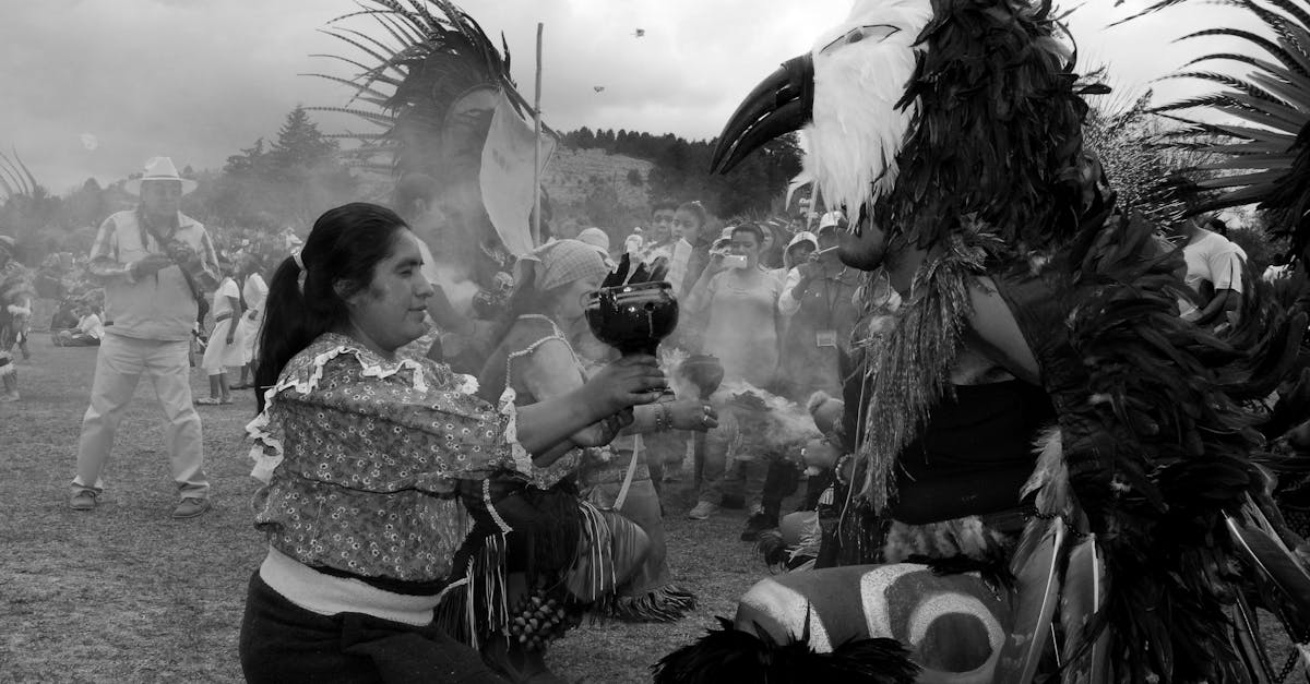 Black and white image of a traditional Mexican festival with people in costumes celebrating outdoors.