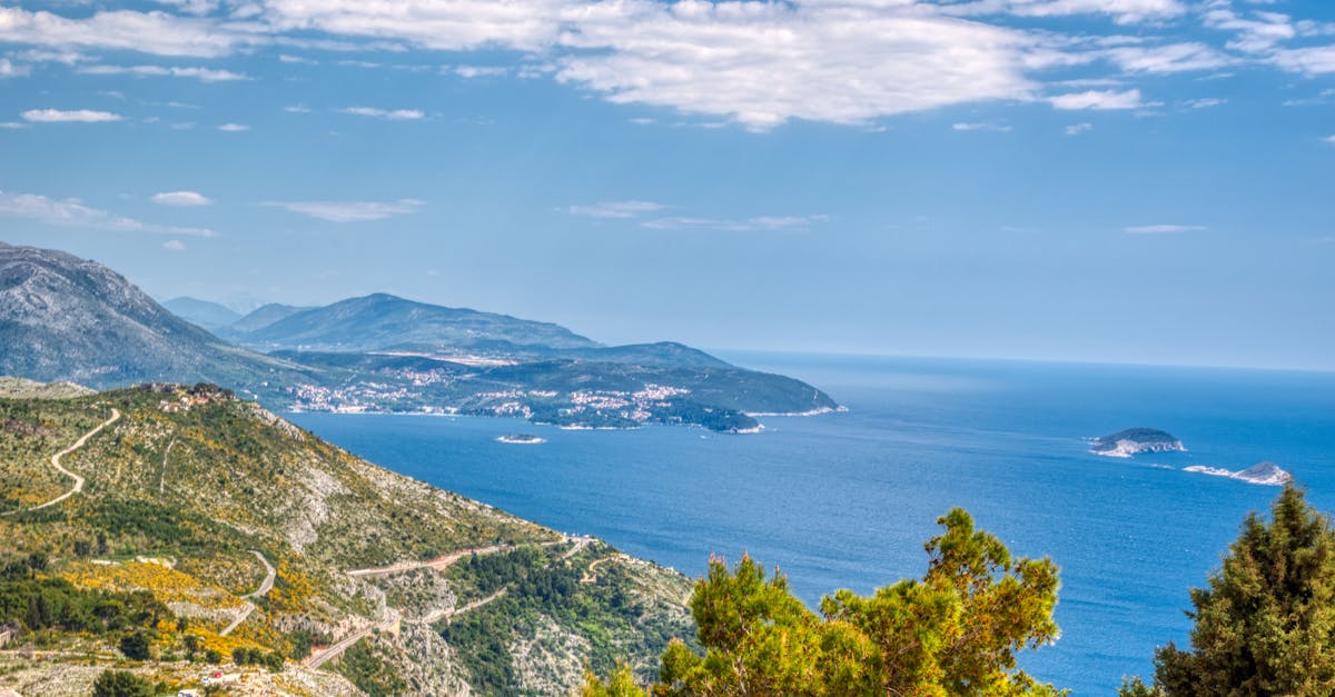 Scenic aerial view of the Dubrovnik coastline and Adriatic Sea on a sunny day.