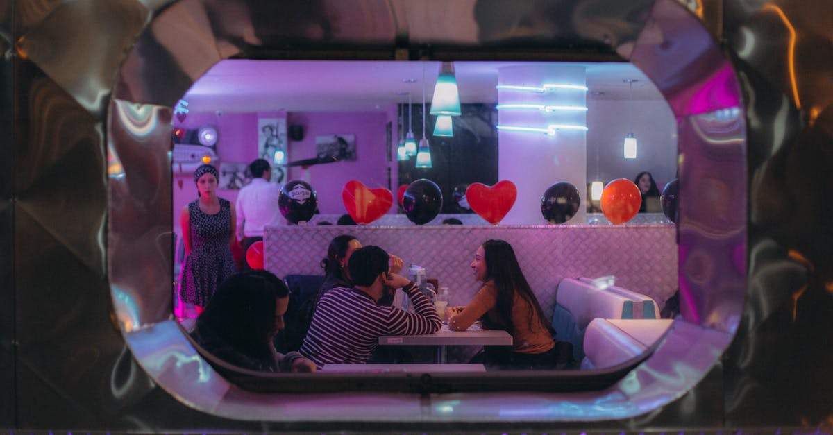 People enjoying a night at a retro diner with neon lights and heart balloons.