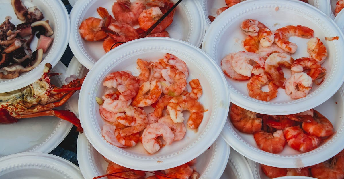 A variety of shrimp dishes served on disposable plates at an outdoor seafood market.