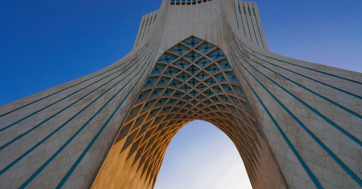 Low angle shot of the iconic Azadi Tower in Tehran against a clear blue sky.