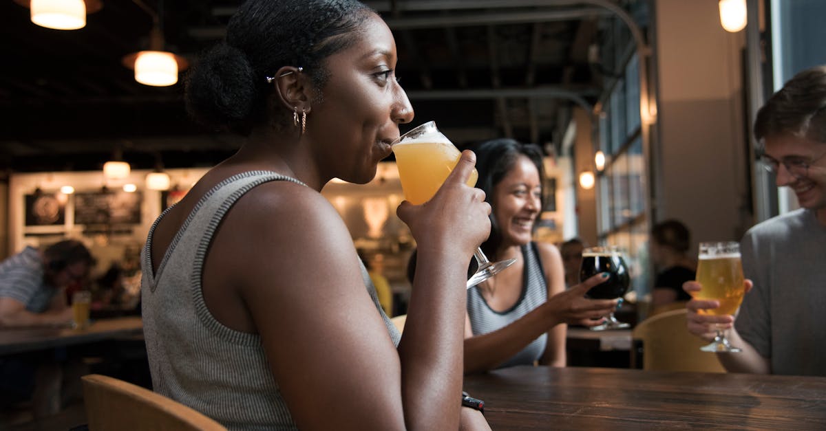 Group of friends having a good time sipping drinks in a cozy bar setting.