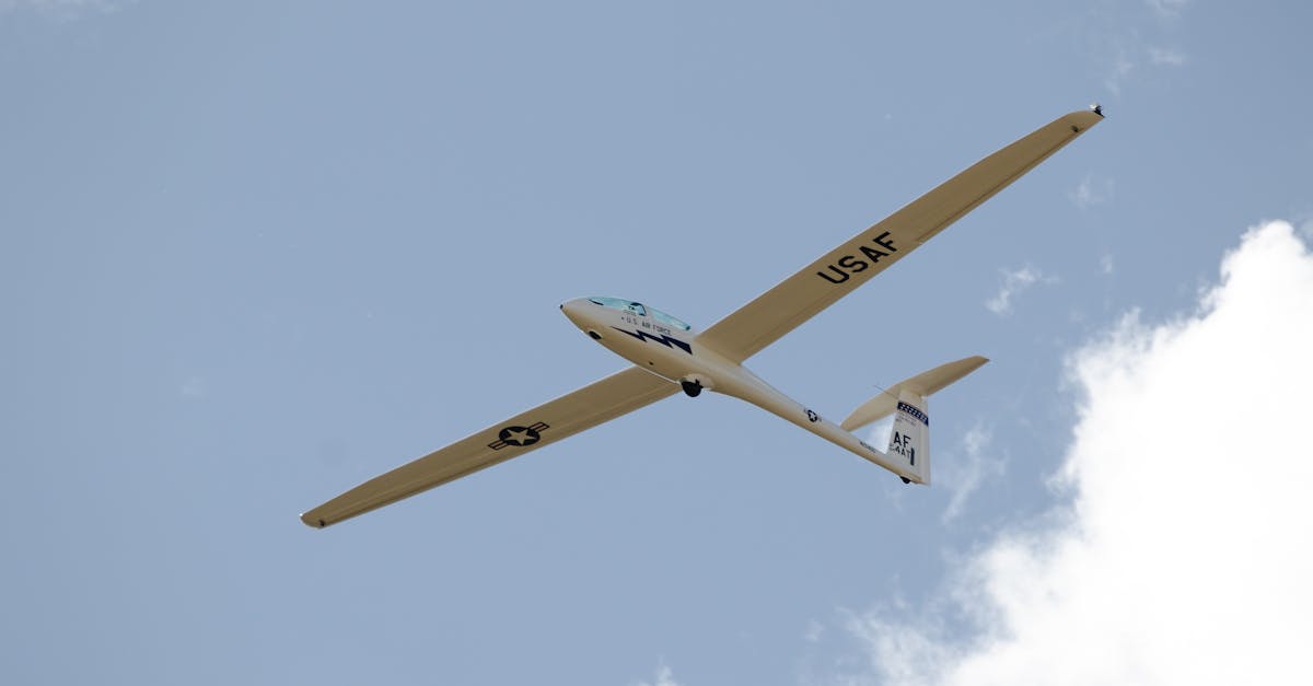 A USAF glider flying high at the Air Force Academy, Colorado against a clear sky.