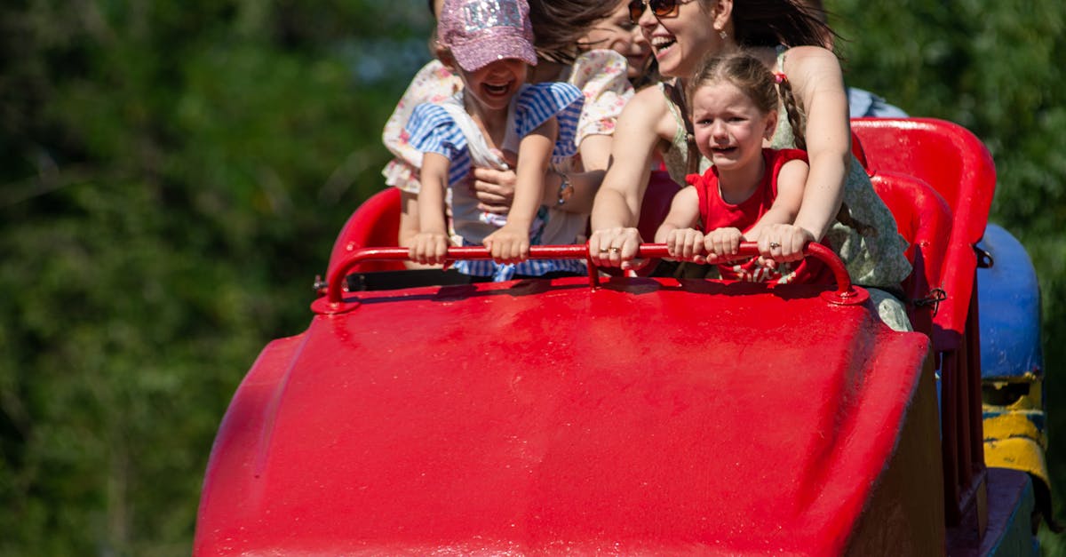 A group of children and adults experience thrill and joy on a roller coaster at an amusement park.