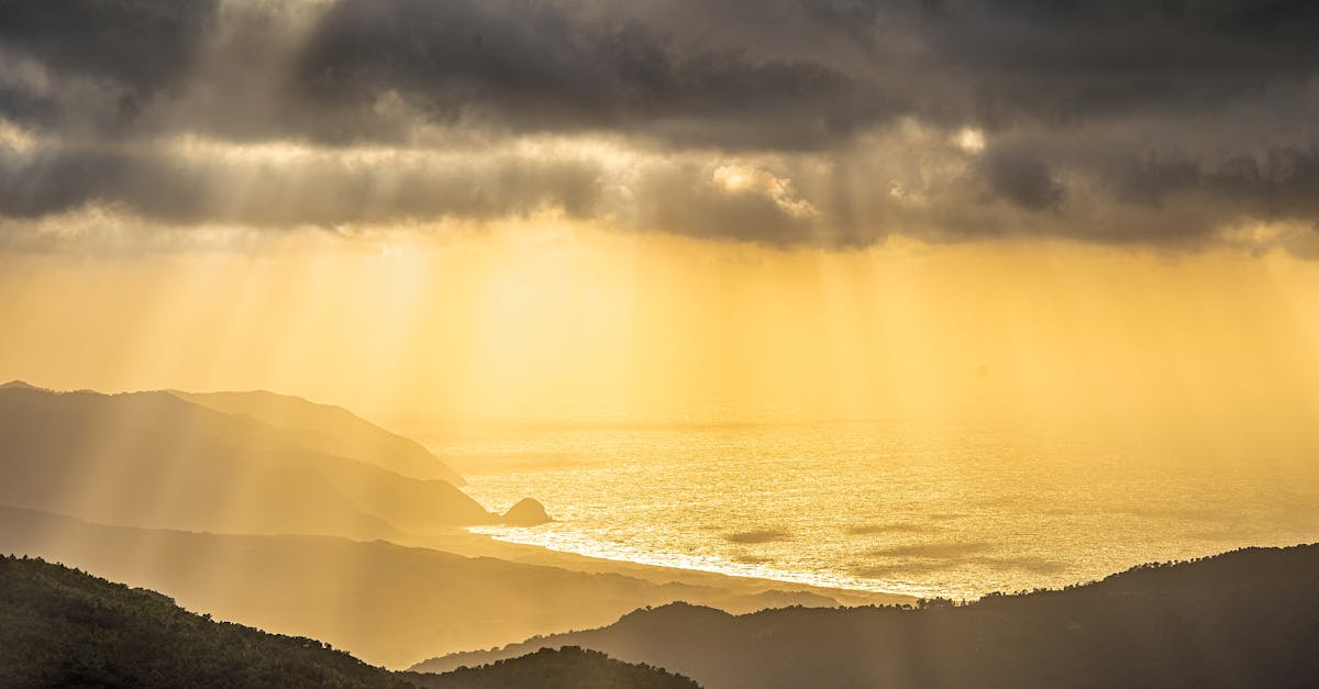 Breathtaking view of Collo, Algeria with golden sun rays piercing through clouds over the sea.