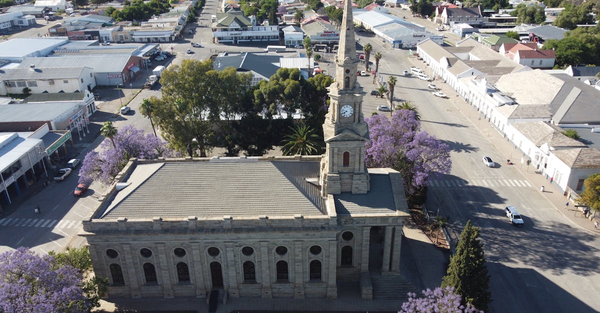 Aerial view of a historic church in Cradock, South Africa surrounded by jacaranda trees and city architecture.