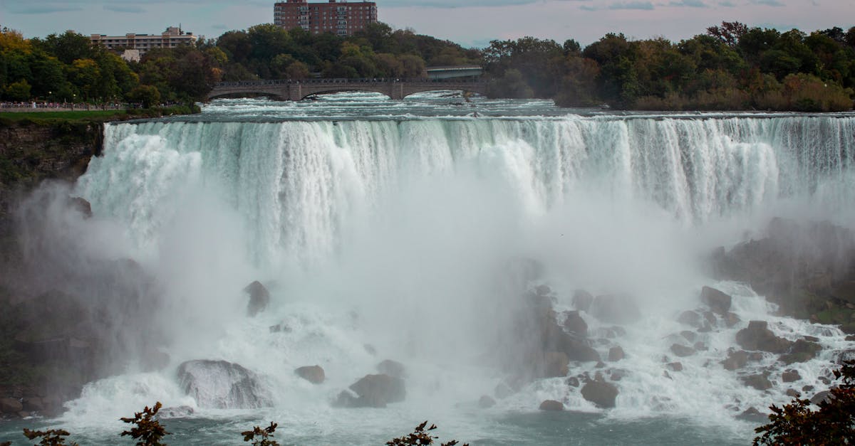 Majestic view of Niagara Falls cascading into the river below on a calm day.