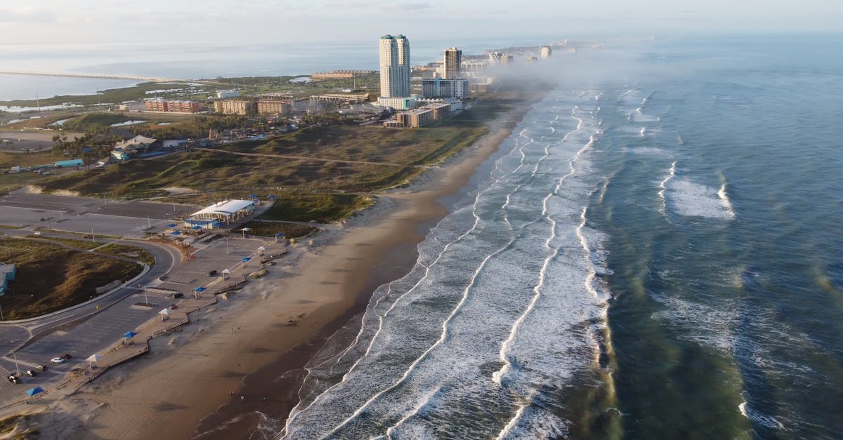 Drone shot of South Padre Island beach with waves and buildings along the coast.