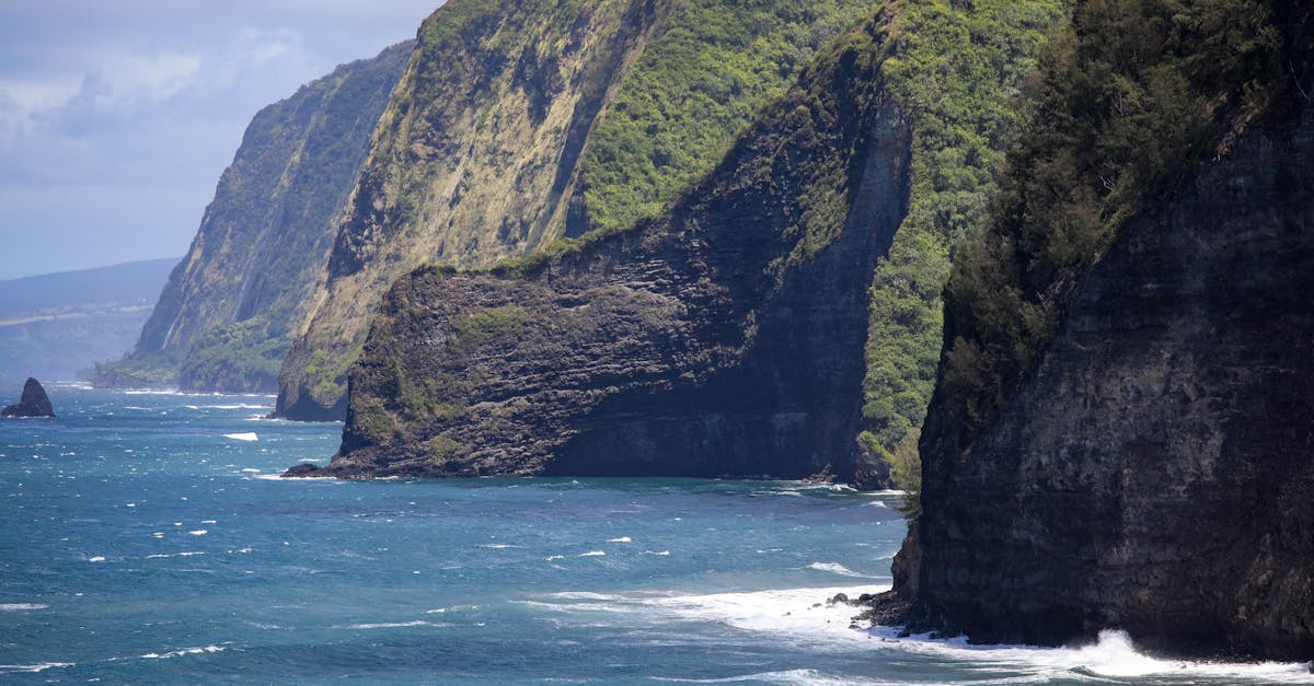 Stunning view of towering coastal cliffs and crashing ocean waves under a clear sky.