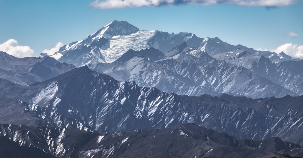 Majestic view of a snow-capped mountain range under a bright blue sky.
