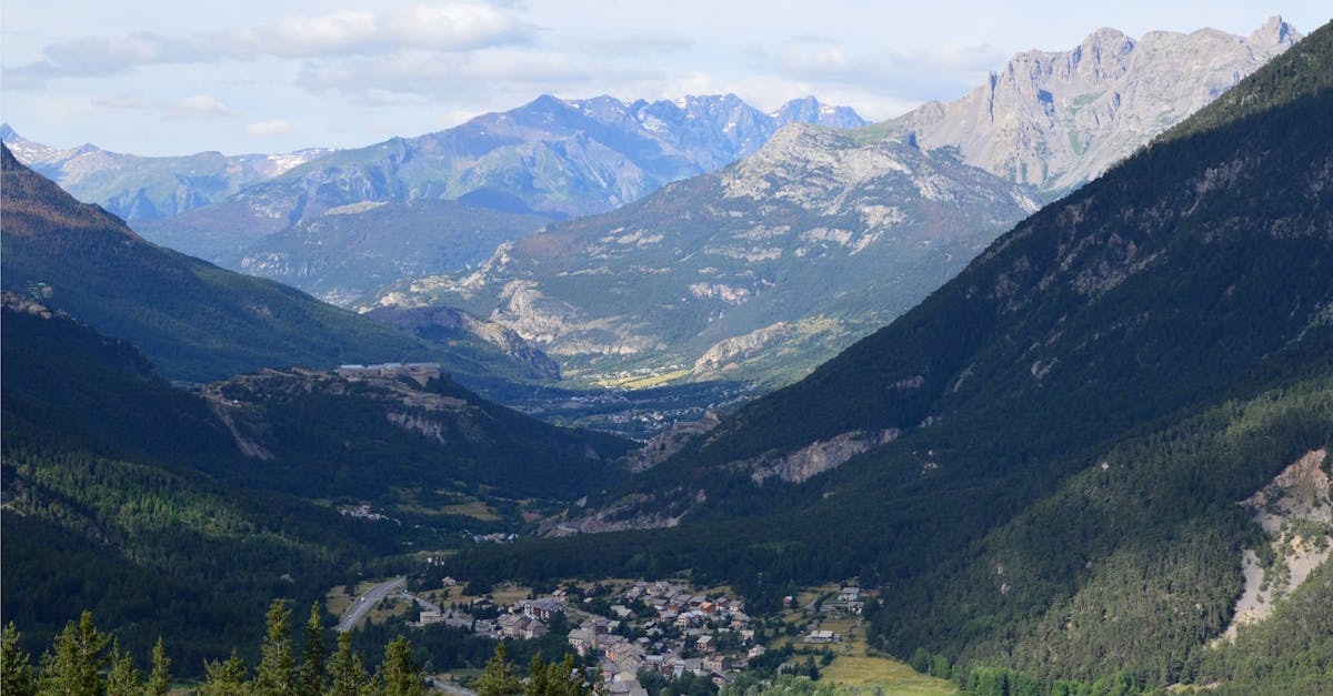 Picturesque mountain valley with a town nestled among lush forests in summer.