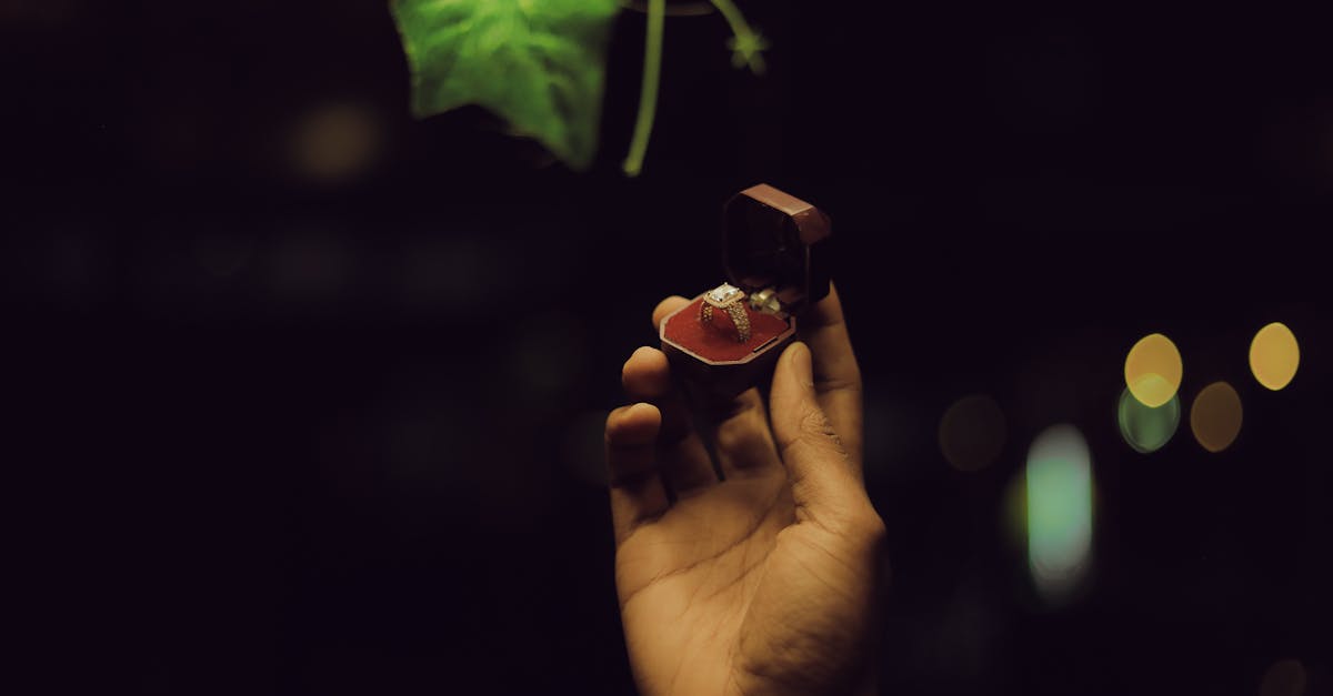 A hand holding a diamond engagement ring in a box at night in Addis Ababa.