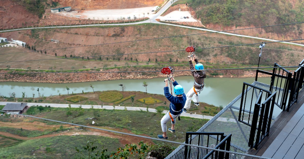 Two people zip lining over a picturesque valley, capturing the thrill of adventure sports.