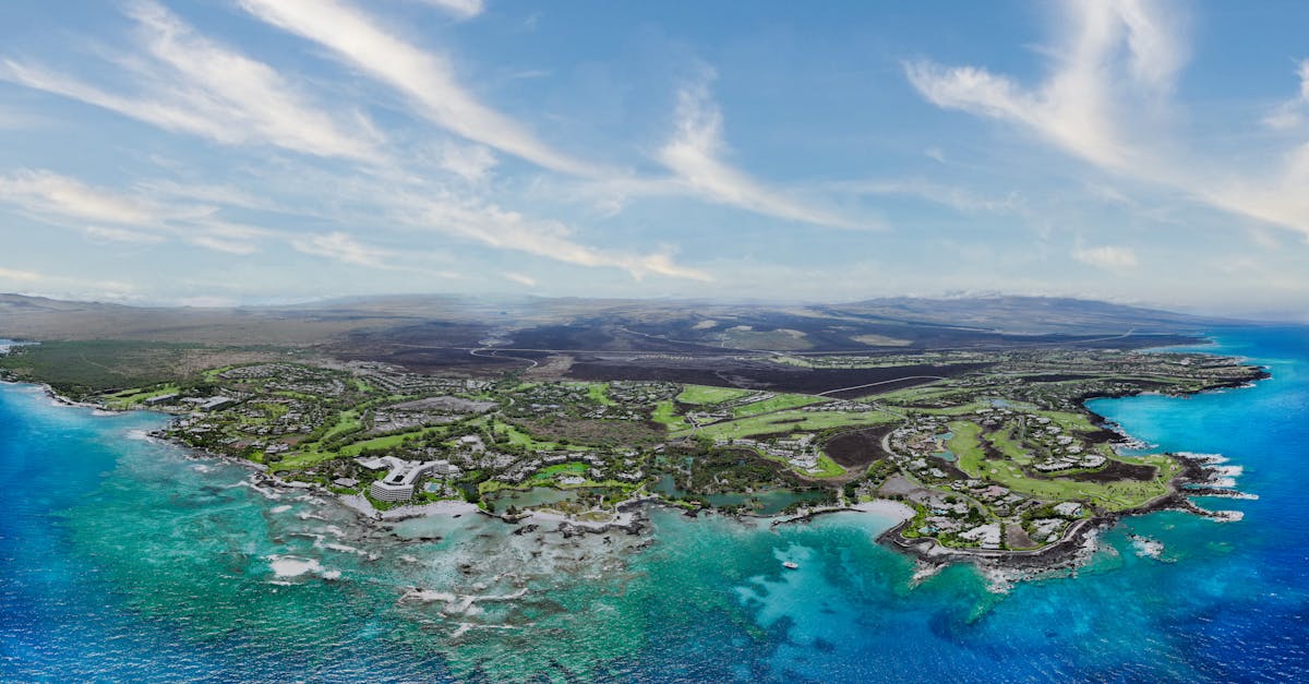Stunning aerial shot of Waimea coastline, Hawaii, with vibrant turquoise waters and lush landscapes.
