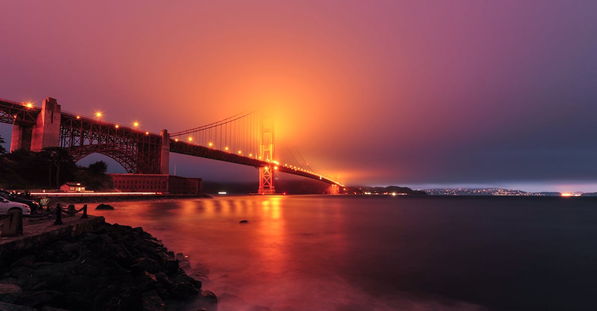 Dramatic view of the Golden Gate Bridge illuminated at twilight as fog rolls in.
