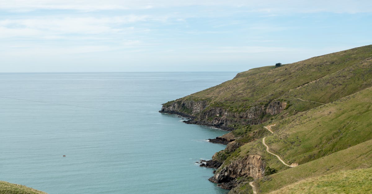 Discover the stunning coastline of Christchurch with lush green hills and serene blue sea.