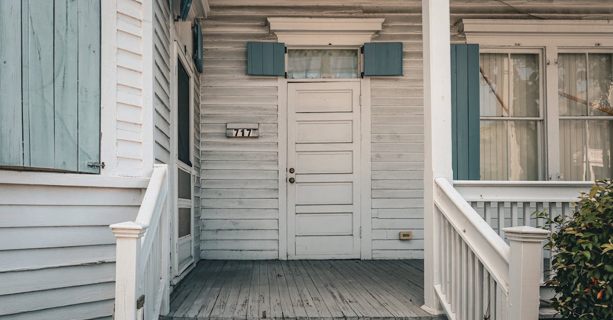 A charming wooden house facade with blue shutters and front porch, exuding vintage warmth.