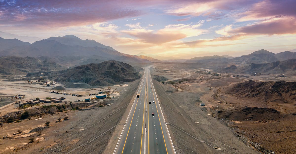 A breathtaking view of a desert highway with mountains in Dubai at sunset.