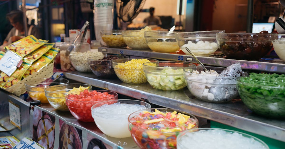 Colorful array of Thai desserts and ingredients at a bustling market stall, showcasing authentic culinary culture.