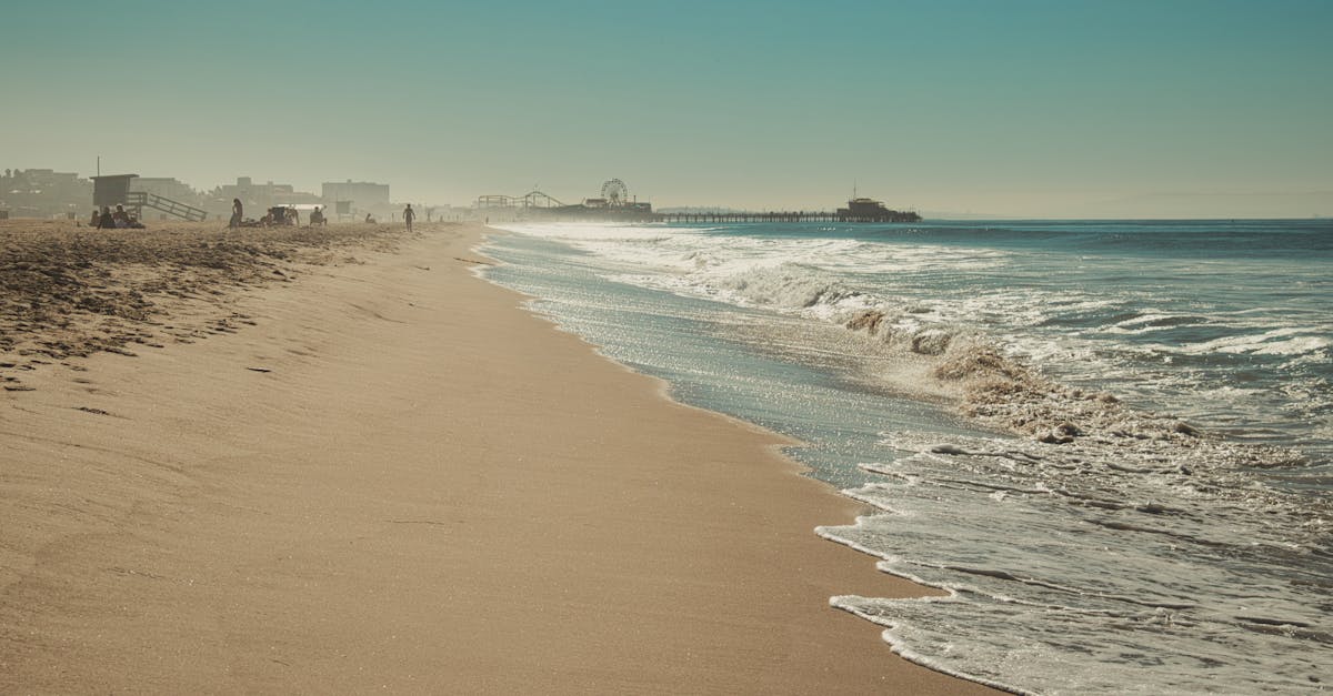 A serene view of Santa Monica Beach showcasing the iconic pier under a clear sky.