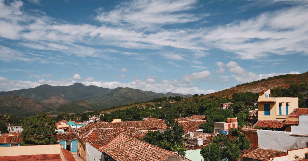 Charming town with colorful rooftops and mountains under a blue sky.