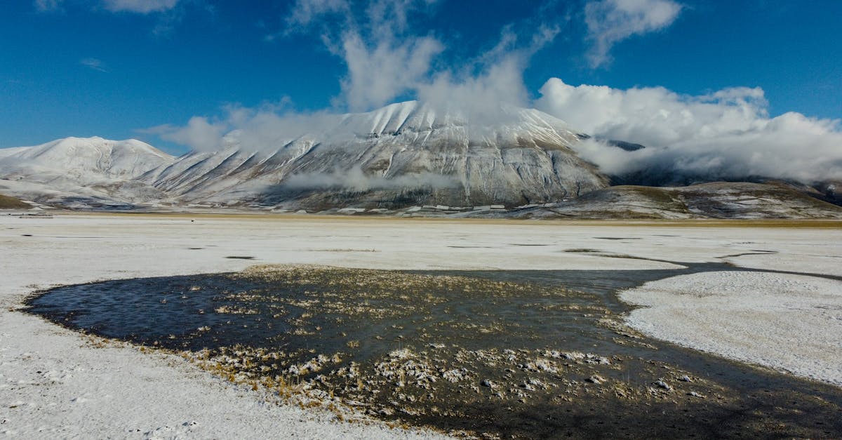 Breathtaking winter view of the snowcapped Apennines with a serene icy valley and clear blue skies.