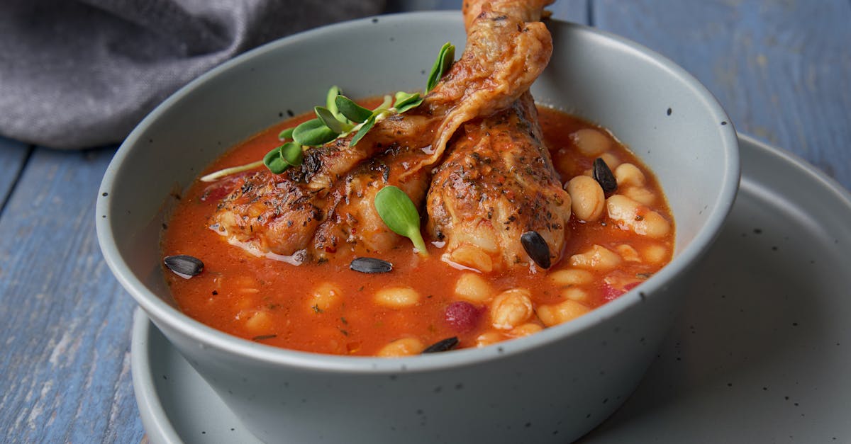 Savor the taste of hearty chicken and bean stew served in a blue ceramic bowl.