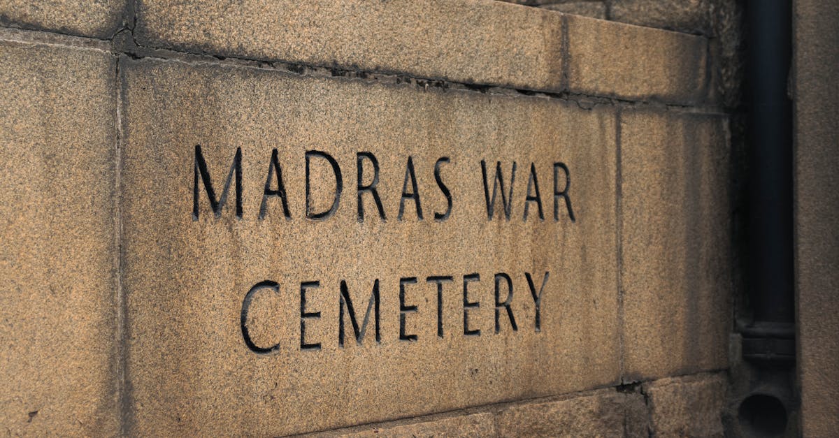 Close-up of stone memorial wall at Madras War Cemetery in India, with engraved text.