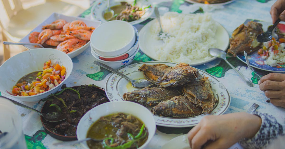 Enjoy a homemade seafood dinner with rice and vibrant side dishes, perfect for shared meals.