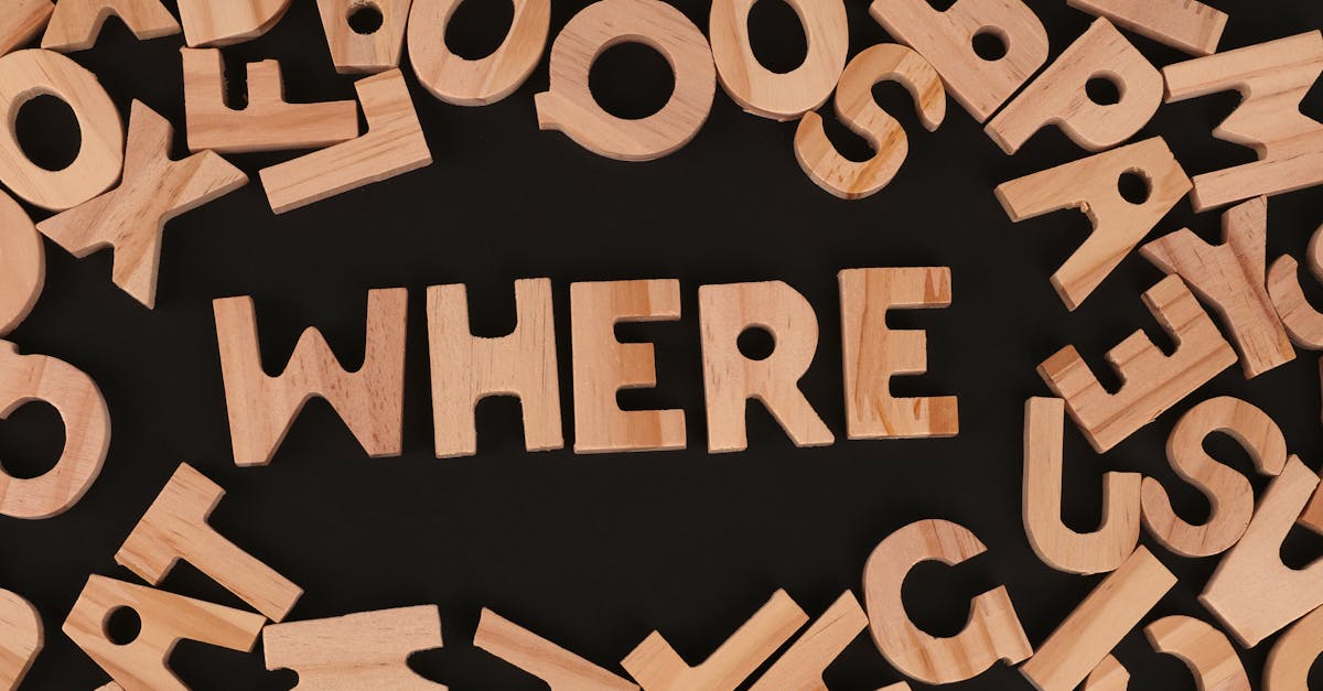 Wooden letters on black background spelling 'WHERE', showcasing typography design.