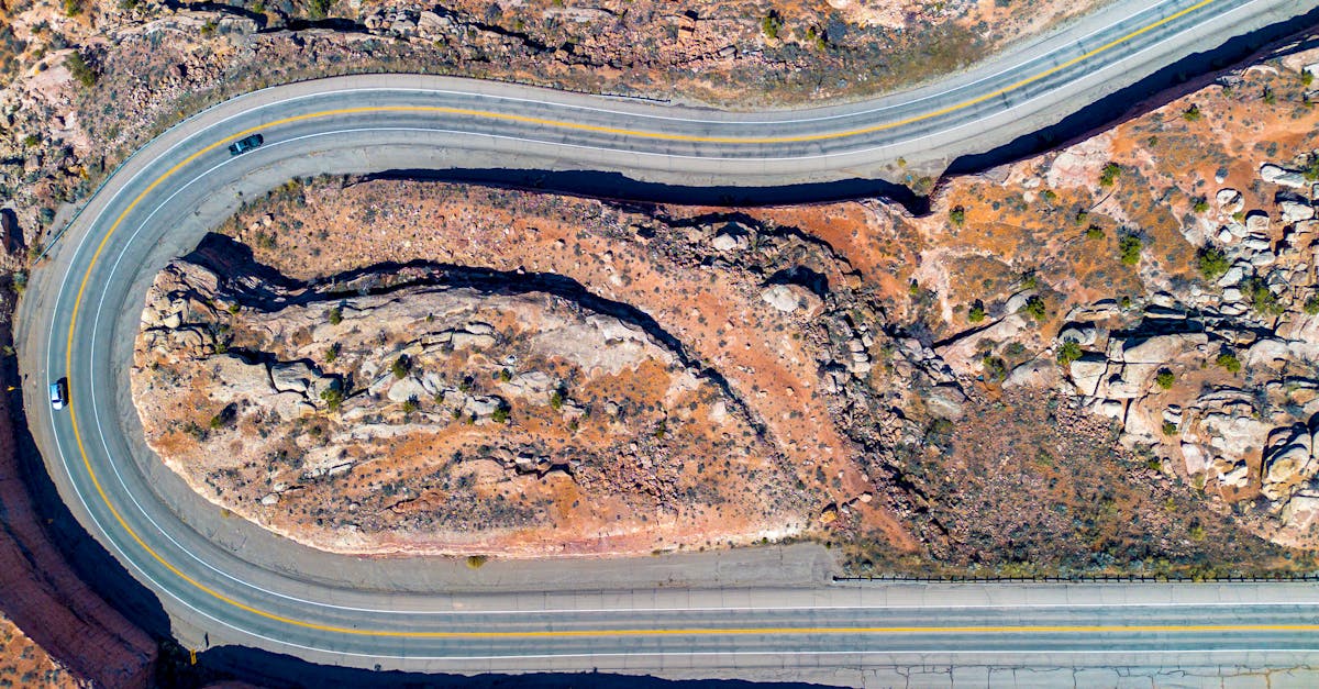 Aerial view of a winding road through the rocky desert landscape of Moab, Utah.
