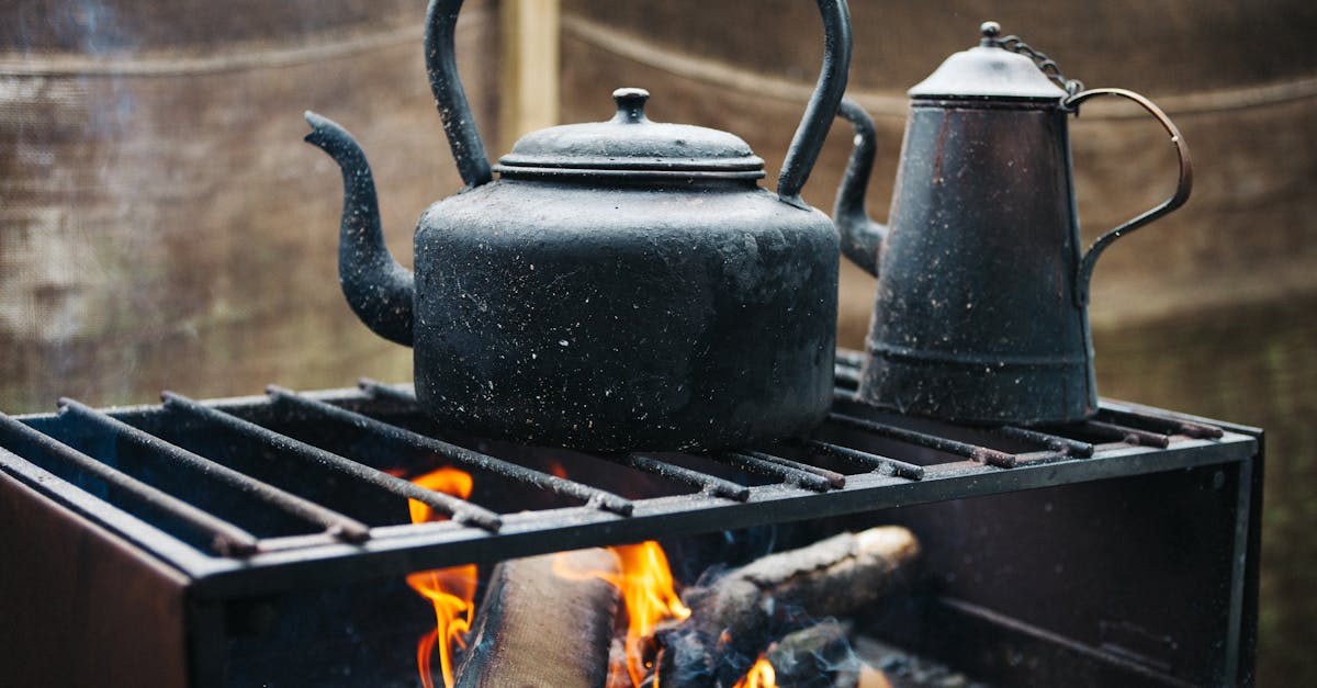 A vintage iron kettle over an open flame, exuding a rustic and warm outdoor ambiance.