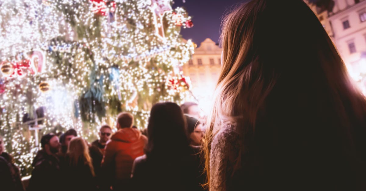 People enjoying a festive Christmas celebration with illuminated trees and joyful atmosphere at night.