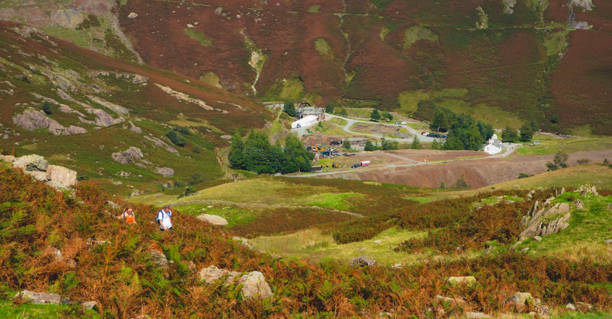 Beautiful rural landscape showcasing hikers in a lush valley surrounded by mountains and nature.