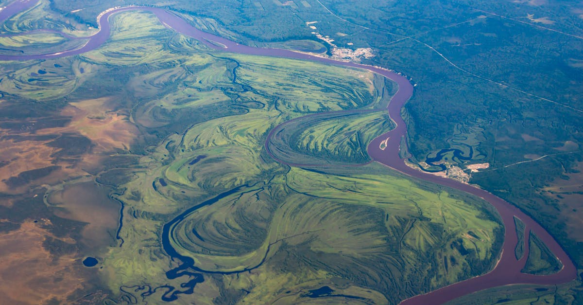 Scenic aerial landscape of river curves amidst lush greens in Khakassia, Russia.