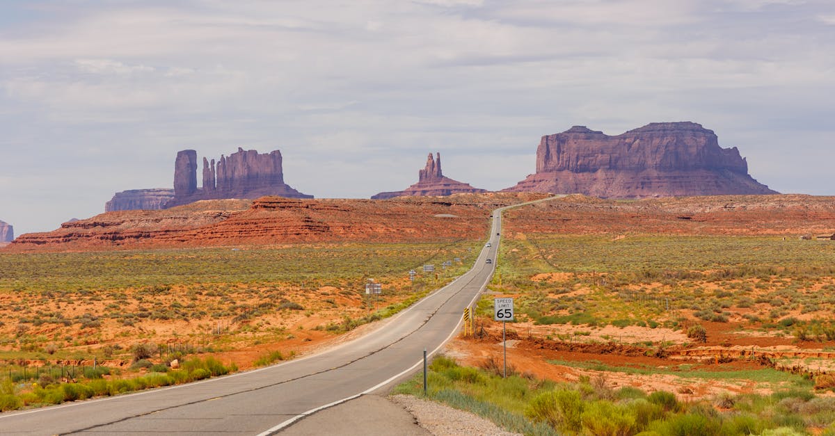 A picturesque road stretching through Monument Valley surrounded by iconic sandstone formations.