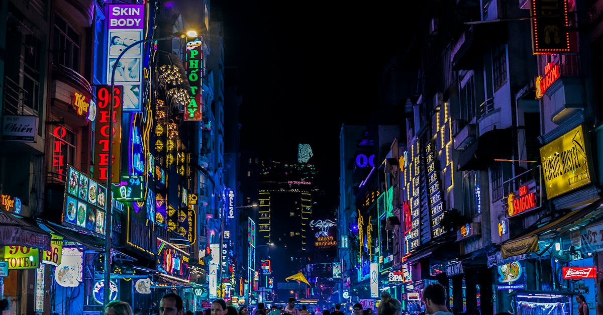 Bustling city street with bright neon lights and crowds at night.