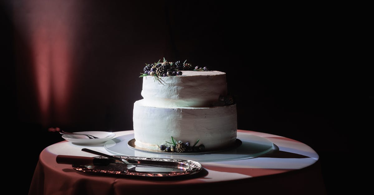 Classic two-tier wedding cake adorned with fresh berries, artfully lit.
