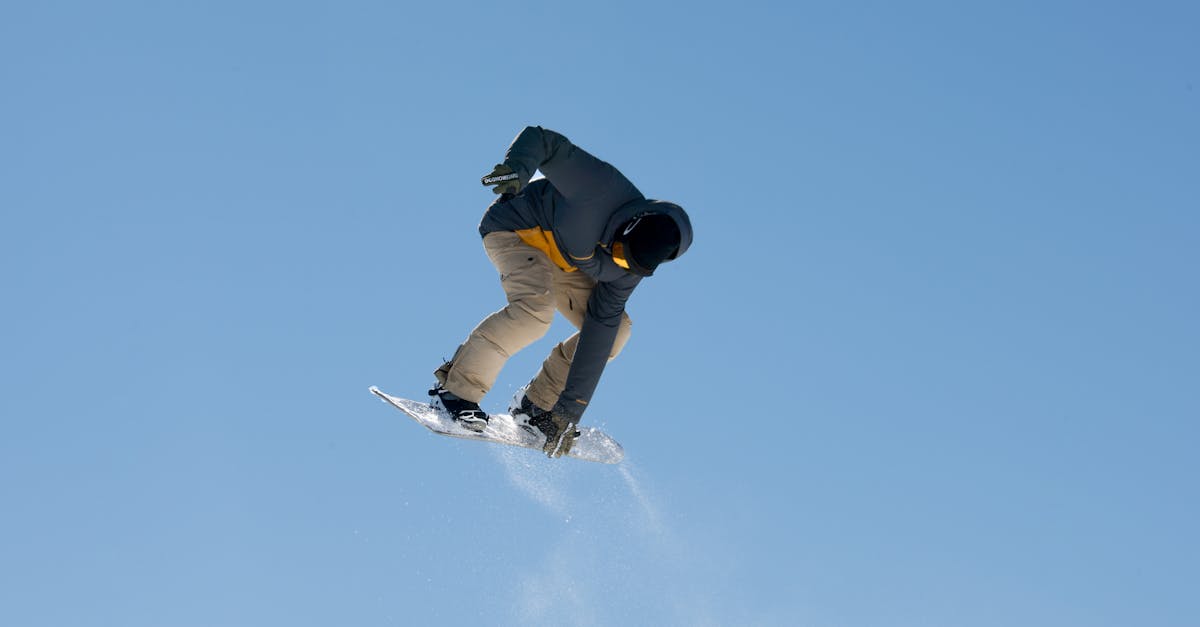 Snowboarder catching air against clear sky in Livigno, Italy.