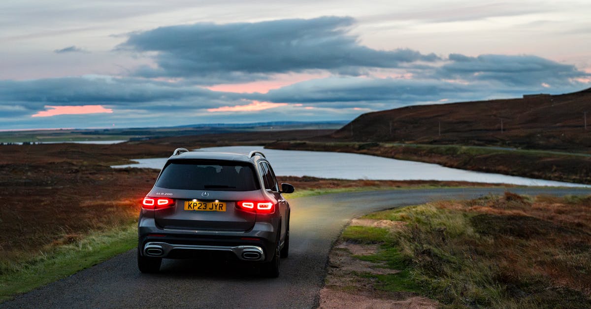 An SUV on a scenic road by a lake during twilight, capturing the essence of adventure and nature.