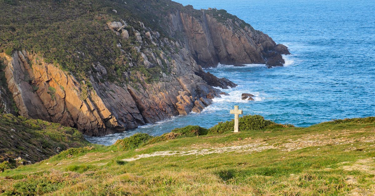 Breathtaking view of Malpica's rugged coastline with a solitary cross overlooking the Atlantic Ocean.