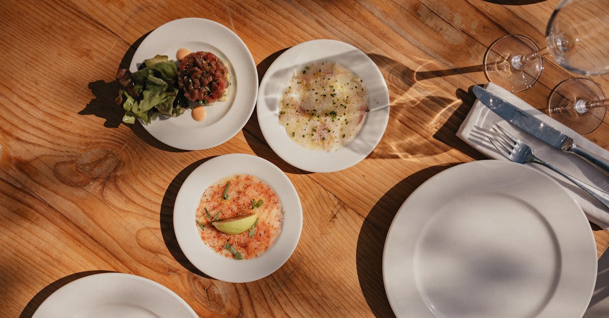 Aerial view of a rustic dining table with elegant appetizers and white plates.
