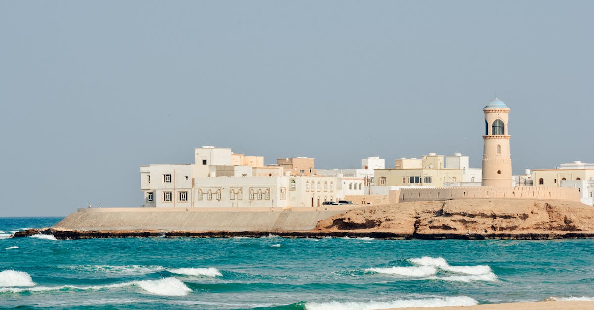 A serene view of Sur Lighthouse and traditional buildings on the Omani coast.