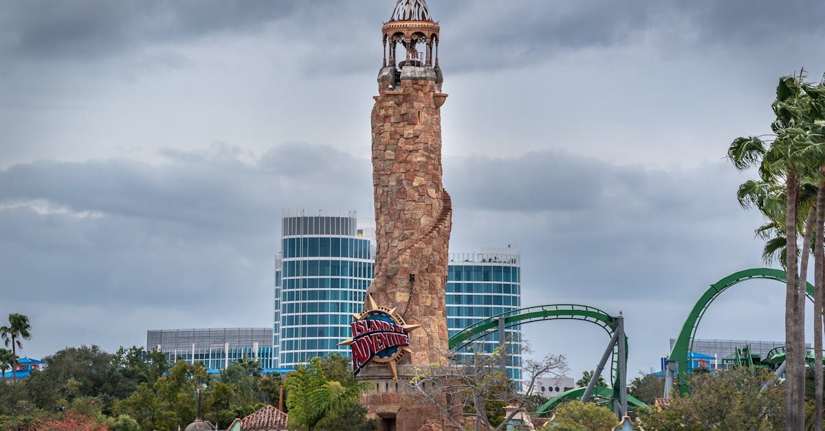 View of the famous Islands of Adventure tower amid lush greenery and roller coasters.